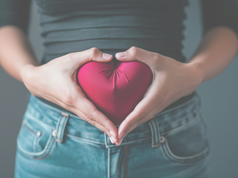 Frau mit Herz vor Bauch und Gebärmutter